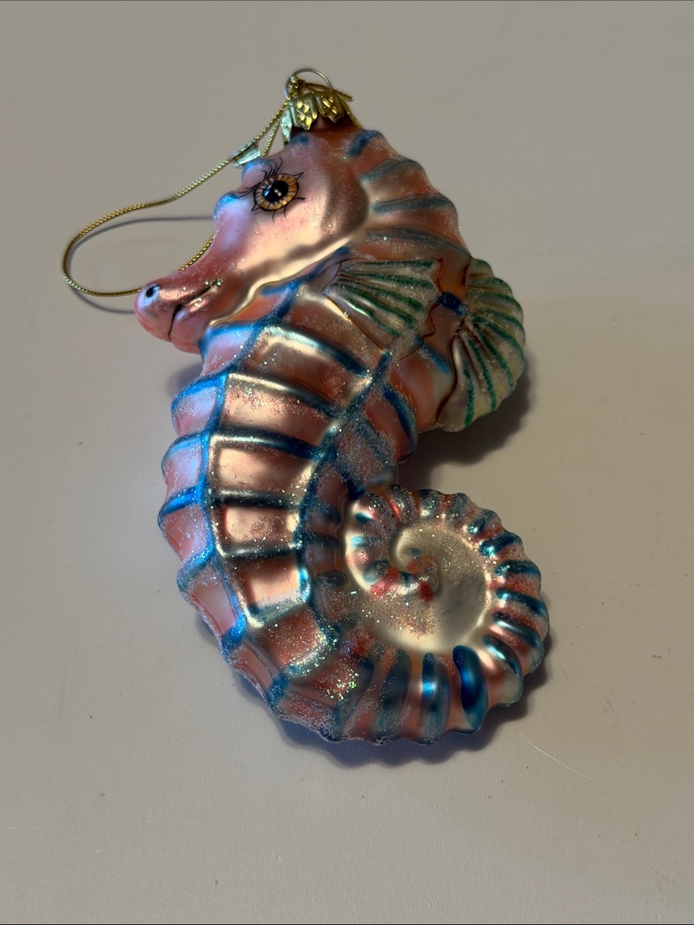 Hand-blown pink and blue sparkling seahorse Christmas ornament.